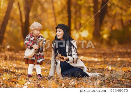 Pregnancy mother with daughter. Family in a autumn park. Little girl in a brown hat Pregnancy mother with daughter. Family in a autumn park. Little girl in a brown hat 93349070