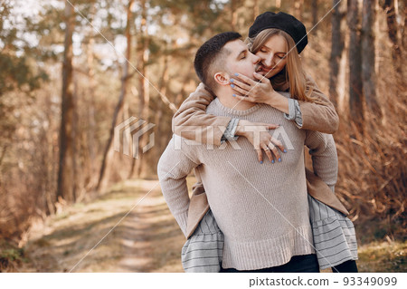 Couple in a park. Blonde in a brown coat. Man with a beard Couple in a park. Blonde in a brown coat. Man with a beard 93349099