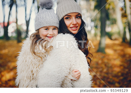 Beautiful mother with daughter. Family in a autumn park. Golden autumn Beautiful mother with daughter. Family in a autumn park. Golden autumn 93349129