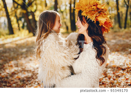 Beautiful mother with daughter. Family in a autumn park. Golden autumn Beautiful mother with daughter. Family in a autumn park. Golden autumn 93349170