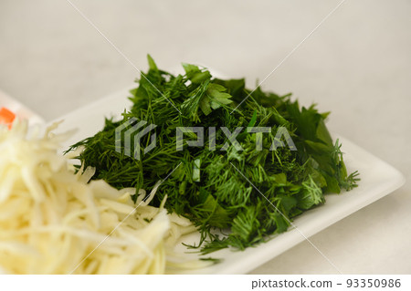 Close-up of chopped dill and parsley for making traditional Ukrainian borscht. Close-up of chopped dill and parsley for making traditional Ukrainian borscht. 93350986