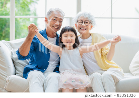 Senior couple relaxing in the living room and grandchildren 93351326