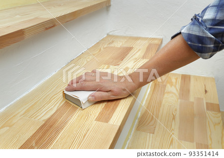 Home renovation, worker sanding wooden stairs Home renovation, worker sanding wooden stairs 93351414