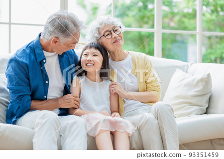 Senior couple relaxing in the living room and grandchildren Senior couple relaxing in the living room and grandchildren 93351459