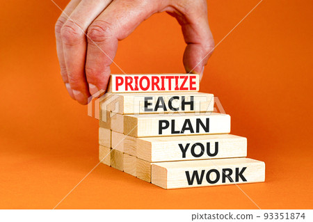 Prioritize each plan you work symbol. Concept words Prioritize each plan you work on blocks on beautiful orange background. Businessman hand. Business prioritize each plan you work concept. Copy space 93351874
