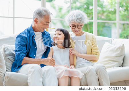Senior couple relaxing in the living room and grandchildren 93352296