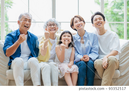 Three generation family sitting on the sofa in the living room 93352517