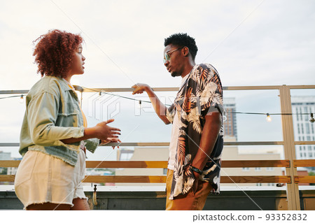 Young black woman in casualwear explaining something to her boyfriend 93352832