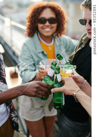 Young cheerful black woman and group of friends clinking with their drinks 93352891