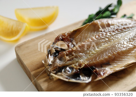 將桌上富含DHA的藍魚切開曬乾，打開曬乾的竹莢魚。 93356320