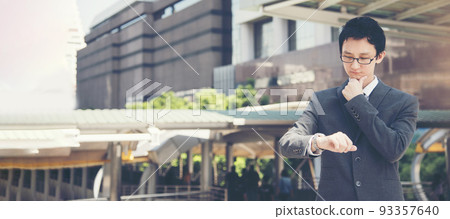 Banner Asian businessman wear suit, eye glasses standing street in modern city. Portrait Young handsome asian man look at bright future smart, confident. Panorama executive man in city outside office Banner Asian businessman wear suit, eye glasses standing street in modern city. Portrait Young handsome asian man look at bright future smart, confident. Panorama executive man in city outside office 93357640