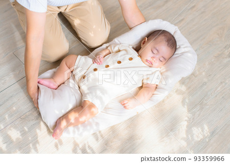 A mother who gently puts down the baby so that it doesn't wake up. A mother who gently puts down the baby so that it doesn't wake up. 93359966