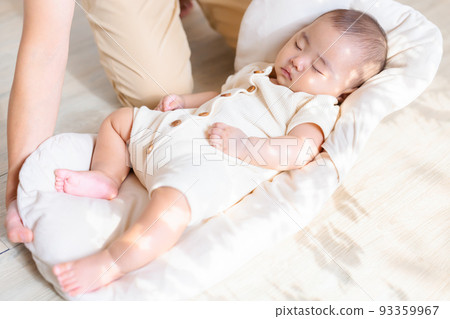 A mother who gently puts down the baby so that it doesn't wake up. A mother who gently puts down the baby so that it doesn't wake up. 93359967