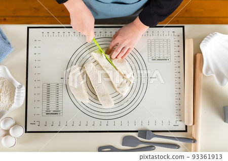 Kitchen silicone baking mat with markings and tips on the home kitchen table in the process of cooking. Top view 93361913
