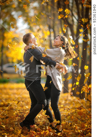 Young couple in love whirl in dance on dating in autumn nature under autumn leaf fall 93361940
