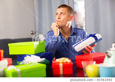 Dreaming man decide who to give boxes of gifts for Valentines Day or international womens day Dreaming man decide who to give boxes of gifts for Valentines Day or international womens day 93361950