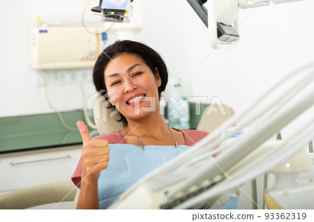 Happy asian woman sitting in dental chair 93362319