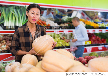 Asian woman choosing pumpkins in supermarket 93362522