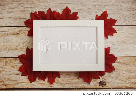 Empty mock up photo frame with maple leaves on wooden background Empty mock up photo frame with maple leaves on wooden background 93365206