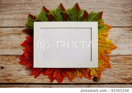 Empty mock up photo frame with maple leaves on wooden background Empty mock up photo frame with maple leaves on wooden background 93365208