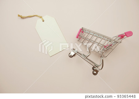 Price tag and shopping trolley cart on pink background 93365448