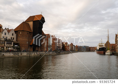 Ancient crane - zuraw Old town in Gdansk. The riverside on Granary Island reflection in Moltawa River. Visit Gdansk Poland Travel destination Ancient crane - zuraw Old town in Gdansk. The riverside on Granary Island reflection in Moltawa River. Visit Gdansk Poland Travel destination 93365724