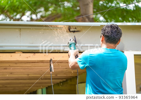 worker cutting the steel stick for home improvement in the garden at noon. 93365964