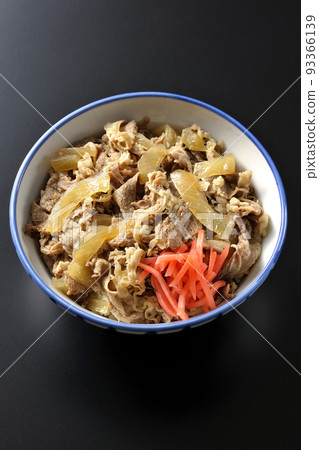 A bird's-eye view shot of a simple beef bowl with red ginger on a black background A bird's-eye view shot of a simple beef bowl with red ginger on a black background 93366139
