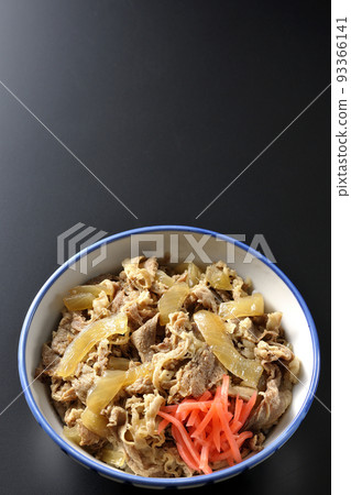 A bird's-eye view shot of a simple beef bowl with red ginger on a black background A bird's-eye view shot of a simple beef bowl with red ginger on a black background 93366141