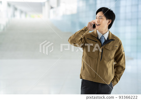 A man in work clothes making a phone call A man in work clothes making a phone call 93366222