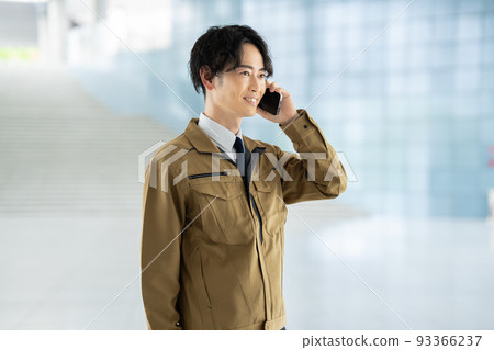A man in work clothes making a phone call A man in work clothes making a phone call 93366237