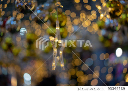 Warm light yellow and orange star shape on the circle glitter bokeh hang on to ceiling for festival or card background. Warm light yellow and orange star shape on the circle glitter bokeh hang on to ceiling for festival or card background. 93366589