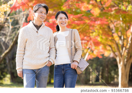 Travel image Middle couple enjoying autumn leaves hunting Travel image Middle couple enjoying autumn leaves hunting 93366786