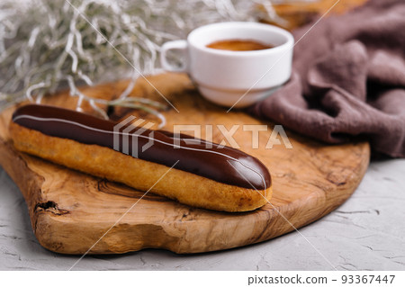 Eclairs with chocolate and a coffee cup Eclairs with chocolate and a coffee cup 93367447