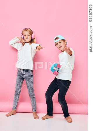 Portrait of two young smiling kids smiling and listening to music in headphones lifestyle childhood 93367566