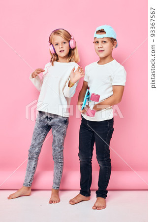 Stylish young friends smiling and listening to music in headphones lifestyle childhood Stylish young friends smiling and listening to music in headphones lifestyle childhood 93367567