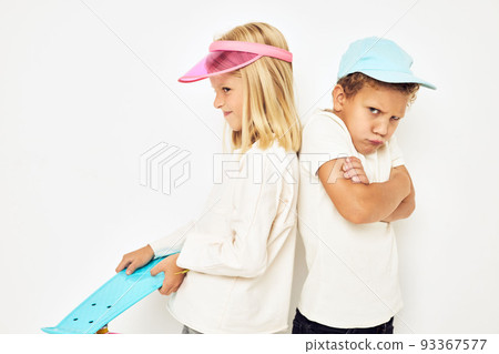 Portrait of two young smiling kids in caps with skateboard studio Portrait of two young smiling kids in caps with skateboard studio 93367577