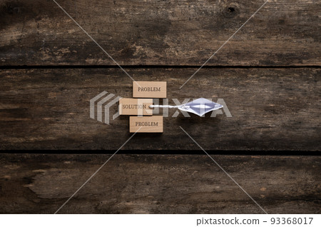 Origami boat dragging a wooden peg with the word Solution on it away from the Problem pegs 93368017