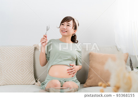 Japanese pregnant woman with spoon and fork (gluttony / meal) Japanese pregnant woman with spoon and fork (gluttony / meal) 93368155