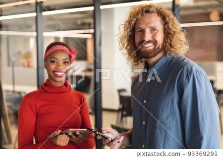 Portrait of smiling multiracial male and female colleagues with smart phones in office Portrait of smiling multiracial male and female colleagues with smart phones in office 93369291