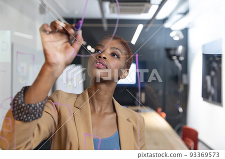 African american young businesswoman planning strategy on glass wall in board room 93369573