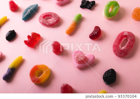 High angle full frame view of multi colored differently shaped sugar candies on pink background 93370104