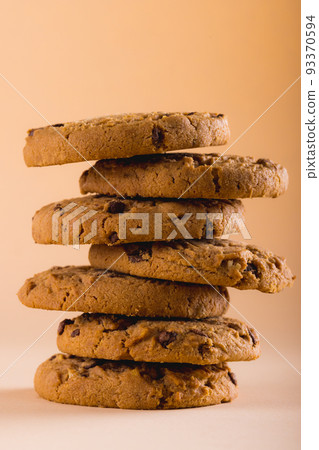 Close-up of stacked cookies against brown background, copy space 93370594