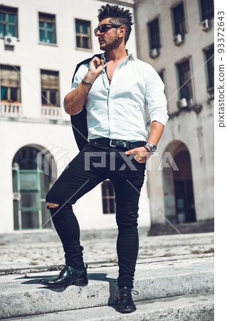 Portrait of a successful young businessman dressed in suit walking down the stairs . Concept Fashionable Young Man 93372643