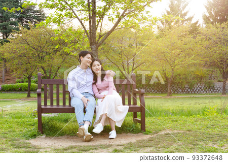 Korean Asian couple enjoying spring date_sitting on the bench Korean Asian couple enjoying spring date_sitting on the bench 93372648