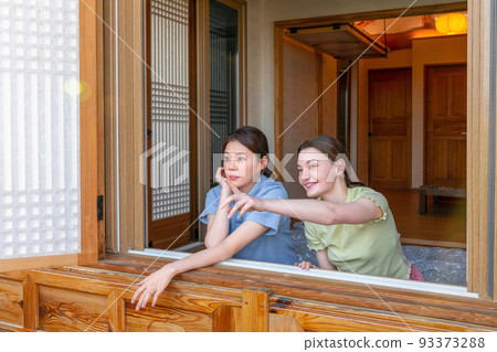 Experience Hanok, Korean traditional house_Korean and Caucasian girls looking outside the window 93373288