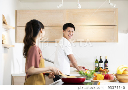 young couple cooking 93375340