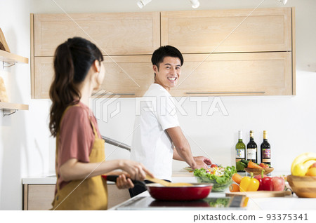 young couple cooking 93375341