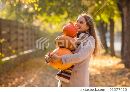 Portrait of happy smile woman with pumpkins in hand. Portrait of happy smile woman with pumpkins in hand. 93377450