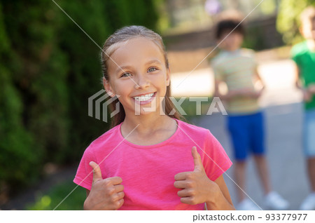 Cute smiling girl showing ok gesture 93377977